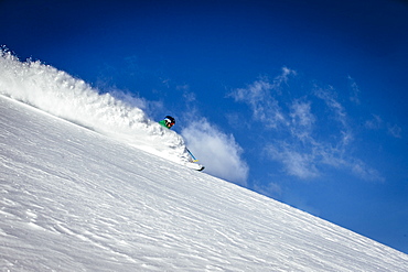 A man skiing fresh snow on a sunny day. Alta, Utah