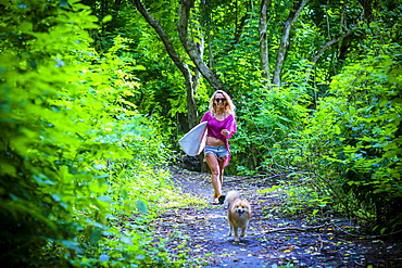 Surfer girl is going to surf spot.