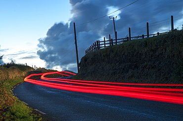 Car streaks on the narrow hillside roads of Dingle