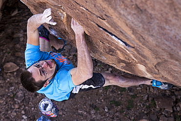 Rock climber on steep overhanging boulder during the Hueco Rock Rodeo in Hueco Tanks State Park, Texas