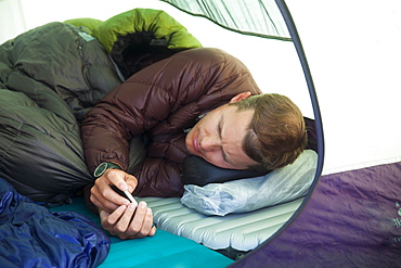 A climber checks his e-mail from his tent while camping in the mountains of British Columbia, Canada.