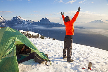 A climber celebrates the beautiful day he woke up to while camping in the mountains of British Columbia, Canada.