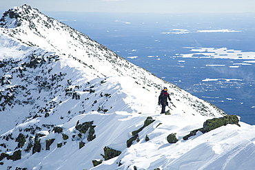 A hiker approaches the summit of Katahdin during a winter hike along the Knife Edge trail in Baxter State Park, Maine.