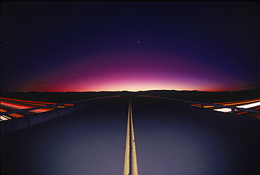 A highway converging at a silhouette of some mountains, California, USA, United States