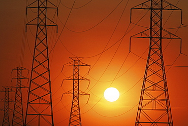 Power lines are silhouetted at sunset in Bakersfield, CA,