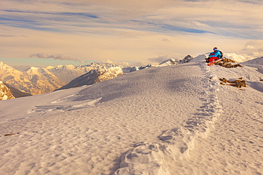 A man takes the last sun before a sunset run on the snow