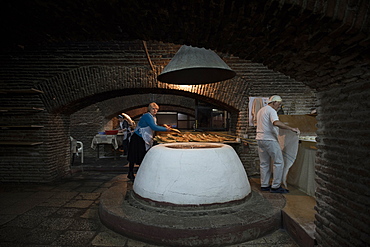 Adjaruli khachapuri bread makers bake traditional Geogian bread in the basement of a building located in the city of Tbilisi, Republic of Georgia.