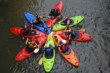 Eight Kayakers form a colorful circle before kayaking big whitewater on the Alseseca River in the Veracruz region of Mexico, United States of America