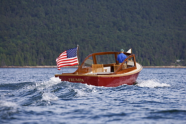 Senior man drives a power yacht in Somes Sound, Maine, United States of America