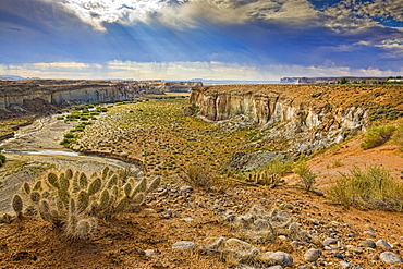 Crumbling cliffs line a canyon above Lake Powell in Big Water, Utah, just north of the Arizona boarder. Rain is clearly visible in the distance, United States of America