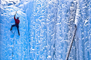 An unidentified lead ice climber tops out on frozen waterfall by a popular climbing area called Haffner Creek in Kootenay National Park, British Columbia on December 1, 2002 as its snows, Canada