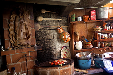 A kitchen decorated with the Our Lady of Guadalupe image in "Tepetlixpa Seed Bank", created by Tomas Villanueva Buendia "Tomaicito" to protect and rescue the original varieties of Mexican corn