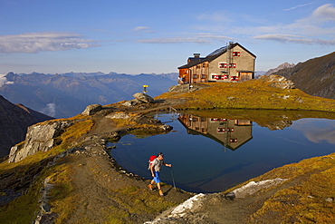 A male hiker at the lake of the Sudetendeutsche mountain hut during the Glocknerrunde, a 7 stage trekking from Kaprun to Kals around the Grossglockner, the highest mountain of Austria.