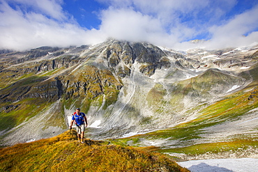 A male hiker during the Glocknerrunde, a 7 stage trekking from Kaprun to Kals around the Grossglockner, the highest mountain of Austria.