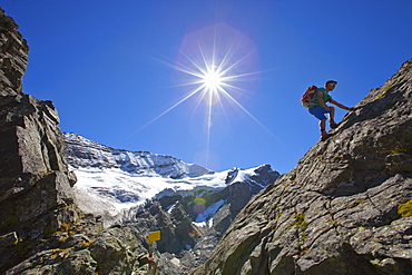 A male hiker climbs a rocky passage during the Glocknerrunde, a 7 stage trekking from Kaprun to Kals around the Grossglockner, the highest mountain of Austria.