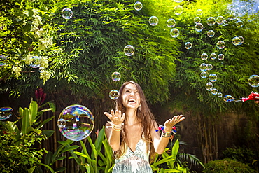 Young Asian womans blowing bubbles.