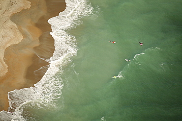 Aerial view of a surf contest, with four surfers in each heat in the water.