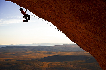 Rock Climber Swinging his feet while grabbing the rock.