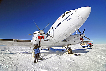 A ski equipped aircraft is being prepared for takeoff near the South Pole.