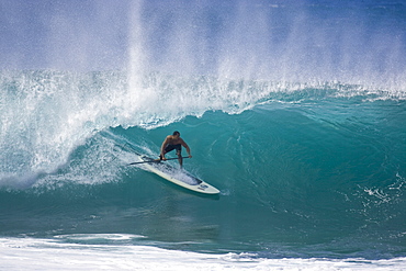 A man stand up paddle surfing, of the north shore of Oahu 02.12.08.