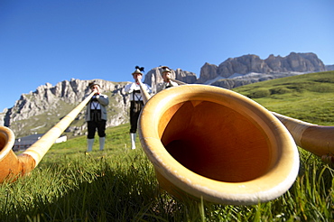 Alphorn players in traditional outfits on the side of the road at Passo Pordoi (2239 m), the second pass of the Maratona dles Do