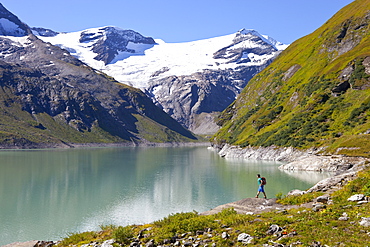 A male hiker near the Mooserboden lake, during the Glocknerrunde, a 7 stage trekking from Kaprun to Kals around the Grossglockner, the highest mountain of Austria.