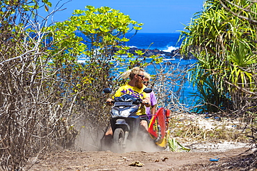 Two surfers travelling by bike.Sumbawa island.Indonesia.