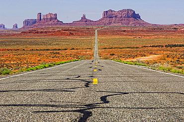 The road that leads to Monument Valley Navajo Tribal Park curves down and then back up again as it approaches the sandstone sculptures that make up the park in Mexican Hat, Utah