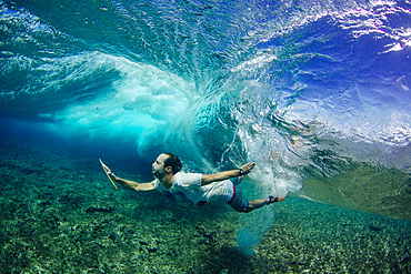 Professional surfer, Indar Unanue, duck dives underneath a wave during a bodysurf session in the South Atolls (Maldives)