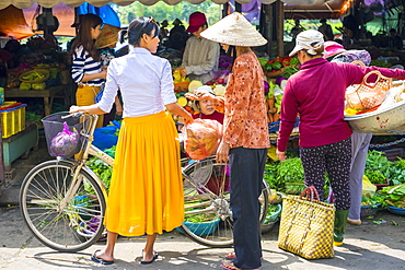 Young Vietnamese woman with bicycle shopping at street market in Hoi An, Quang Nam Province, Vietnam