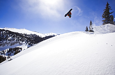 A man hits a backcountry jump on his snowboard on Red Mountain Pass in Southwest Colorado.