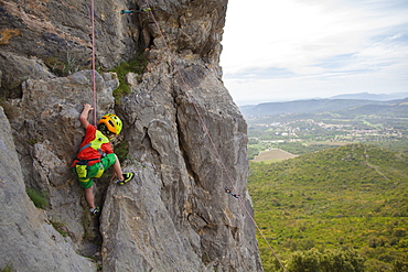 A little boy, 3 years- old, climbing in Corsica, France.