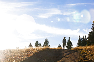 A man stands in a meadow, White River National Forest, Colorado.