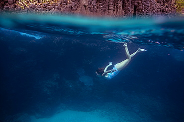 Young woman diving underwater.