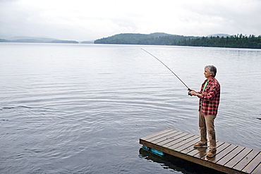 Senior man fishing off dock at Kezar Lake