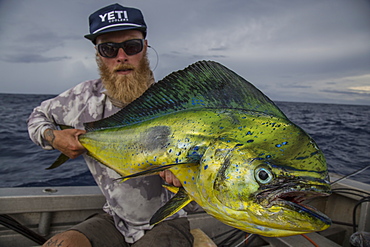 Angler Jonathan Jones holds up a mahi-mahi caught while fishing off the shore of Samoa.