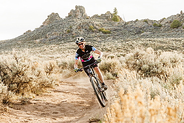 Person Mountain Biking On Trail In Desert Landscape