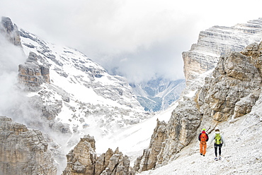 A Couple Hiking Down The Summit Of Punta Anna In Tofana Di Mezzo