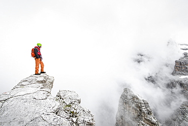 The Italian Guide Standing On Exposed Ridge Near The Summit Of Punta Anna