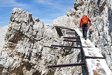 Man Walking Through An Old Bridge At The Via Ferrata Ivano Dibona