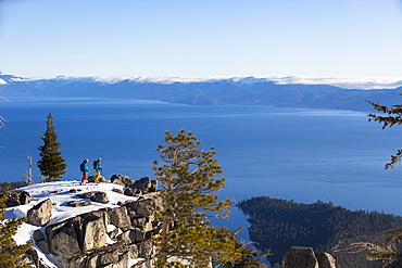 Long Exposure Of Two Skier Standing On Rock In Lake Tahoe, California, USA