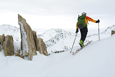 A man passing granite spires on a backcountry ski tour in Little Cottonwood Canyon