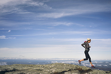 Woman Running On A Rocky Ridgeline Of Mount Mansfield, Vermont