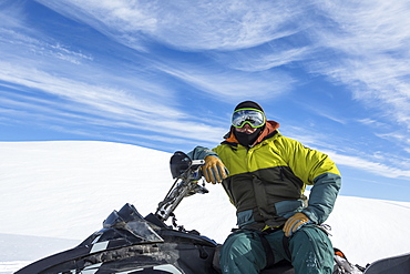 Portrait of a man sitting on snowmobile in Northern British Columbia