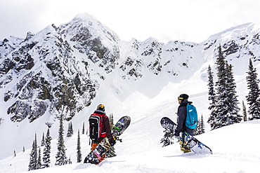 Two Friends With Snowboard Hiking In Snowy Region