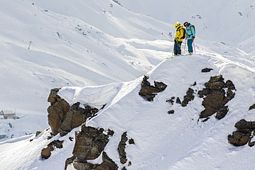 Two Skiers Talking About Their Line Before Dropping In The Face