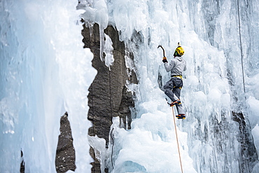 Male Climber Ice Climbing In Ceresole Reale Ice Park, Piemonte, Italy