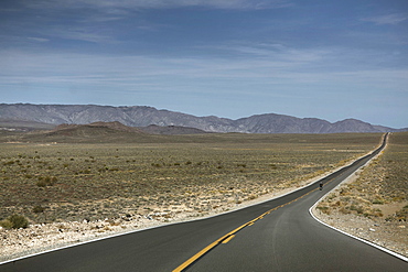 A Person Rides A Motorcycle On A Road Leads To Death Valley Of California