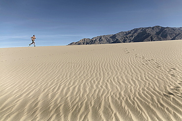 A Person Running In Desert Landscape In Death Valley Of California, Usa