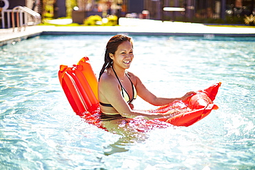 Happy Asian Woman Having Fun With An Air Bed In Pool